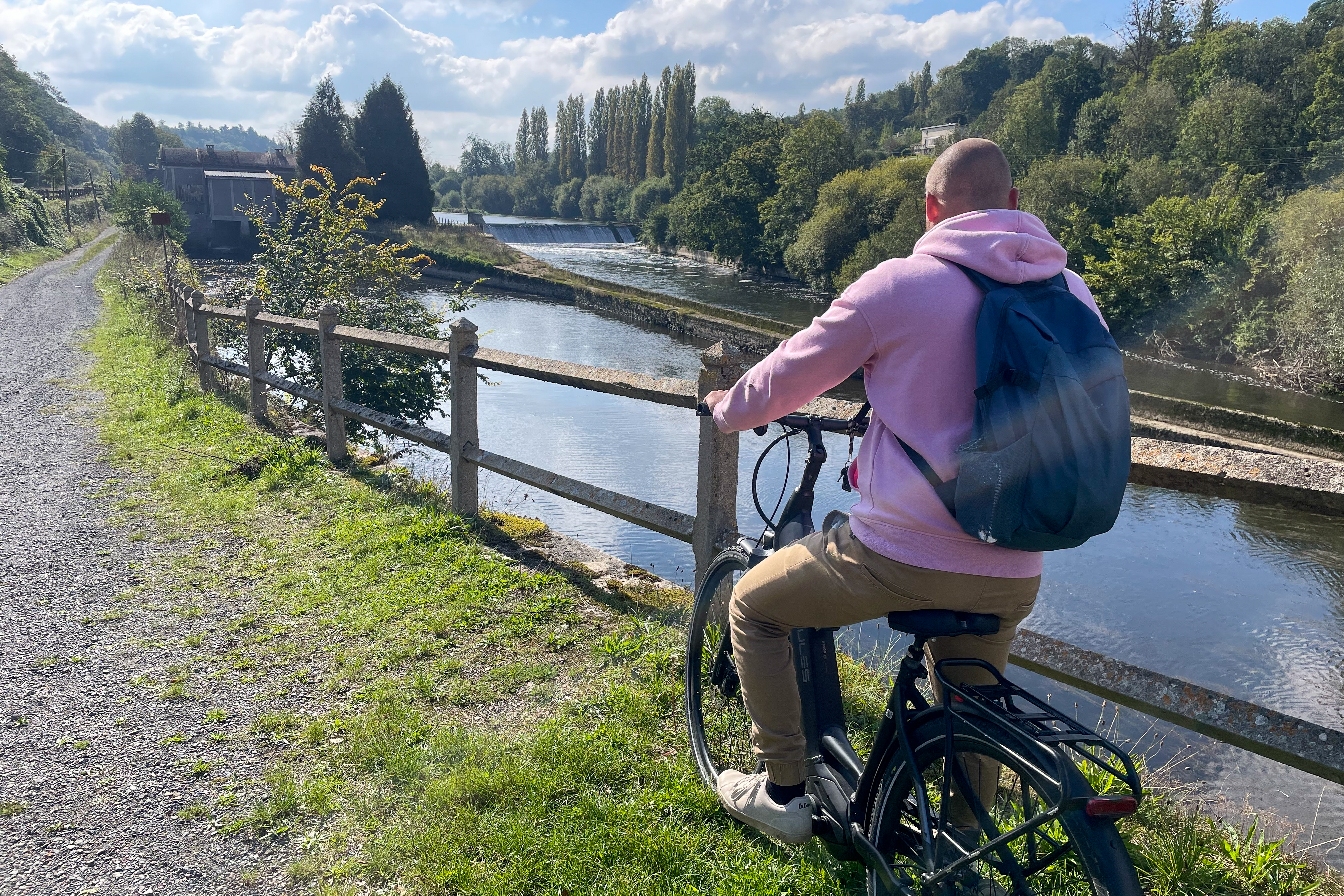 Yn cycliste regardant de la rivière proche d'une piste cyclables